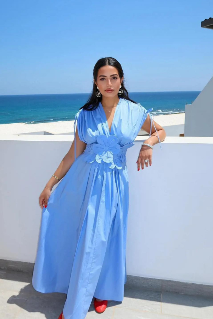 Cornflower blue puff-sleeve maxi dress with floral waist detail by the sea