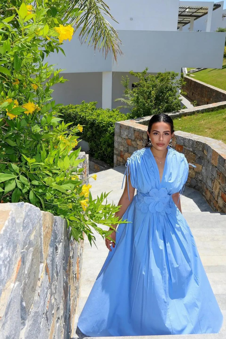 Cornflower blue floral-waist maxi dress worn on a sunny garden pathway