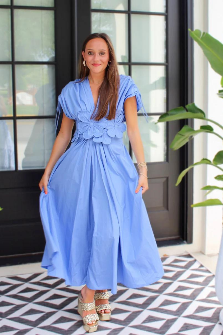 Cornflower blue maxi dress with tie-cuff sleeves at a courtyard doorway