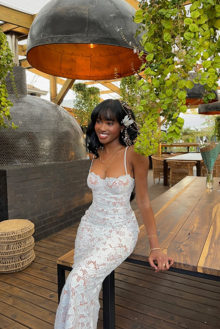 Flowing white lace maxi dress skirt captured mid-movement