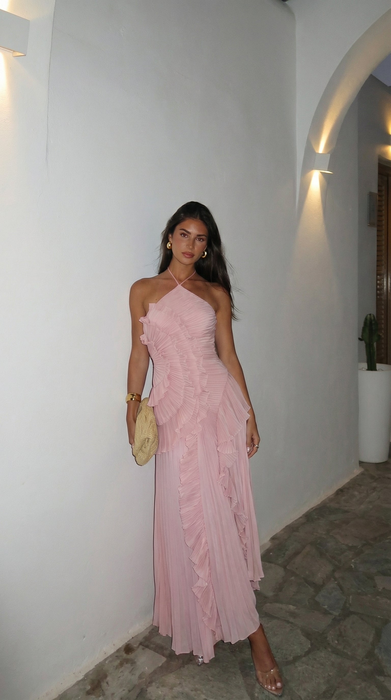 Baby pink halter maxi dress worn in a hallway setting