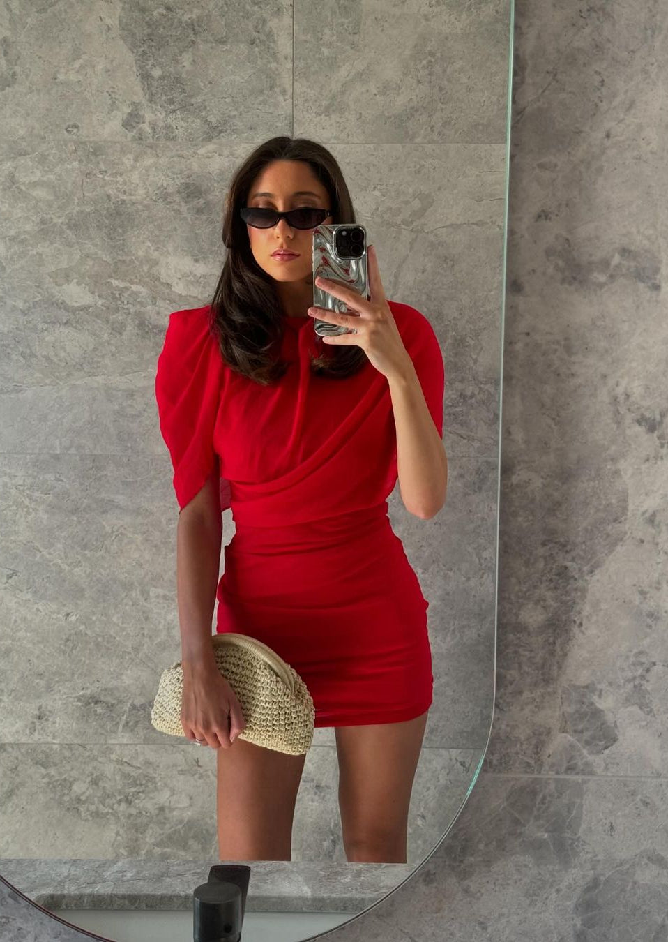Red chiffon mini dress shown with its structured shoulder detail.
