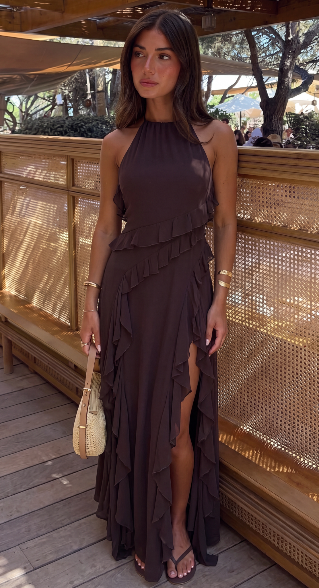 Brown ruffle halter maxi dress with side split, worn on a deck
