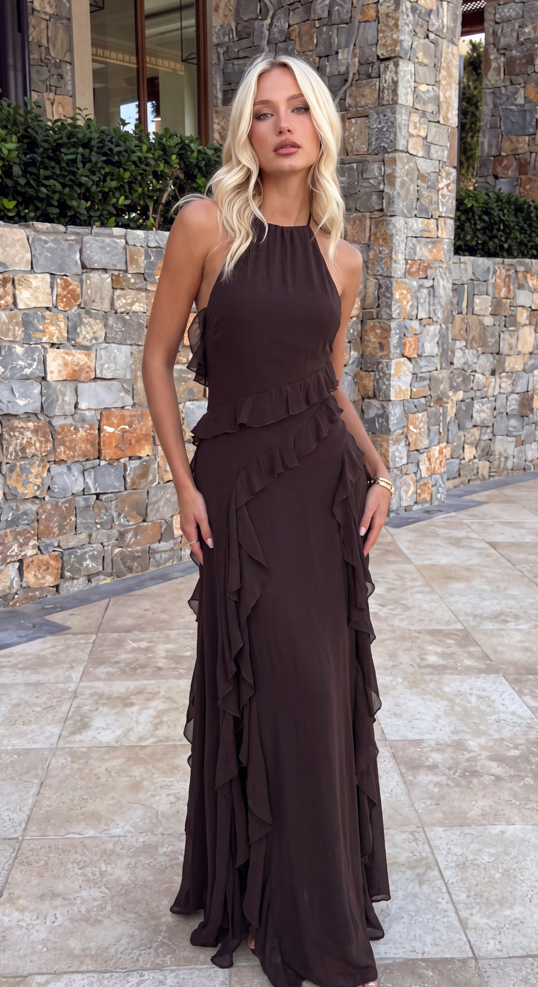 Brown beaded halter maxi dress worn against a stone wall