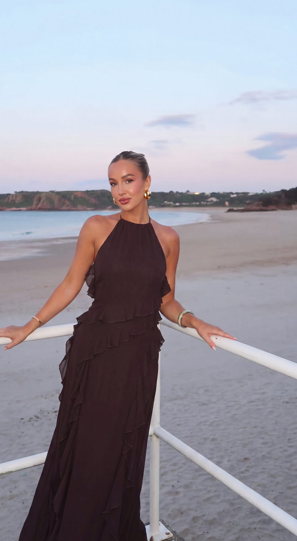 Brown halter maxi dress with side split worn on a beach boardwalk
