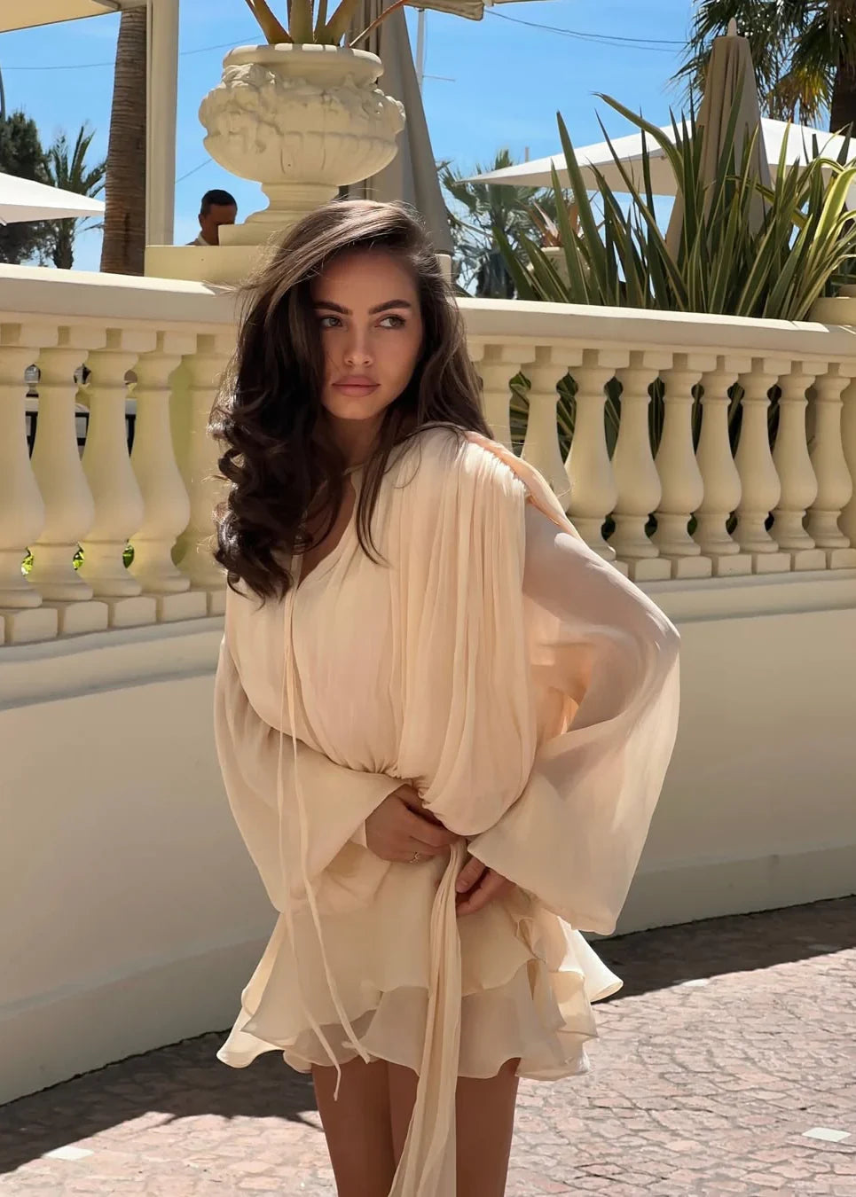 Beige ruffled mini dress shown from the back, full length