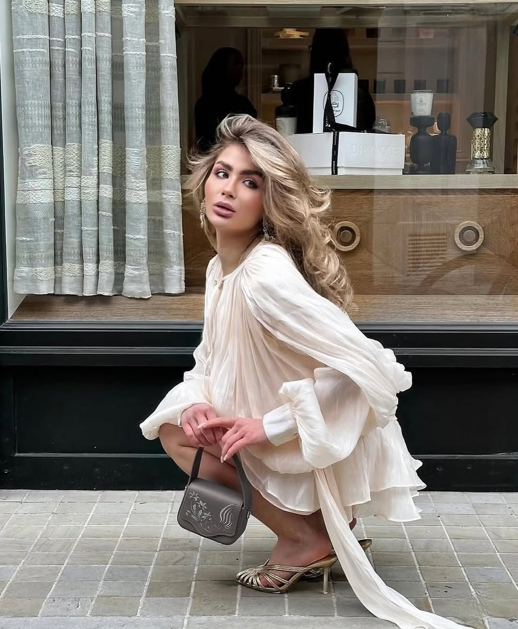 Beige ruffled mini dress styled for an evening occasion