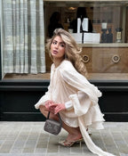 Beige ruffled mini dress styled for an evening occasion