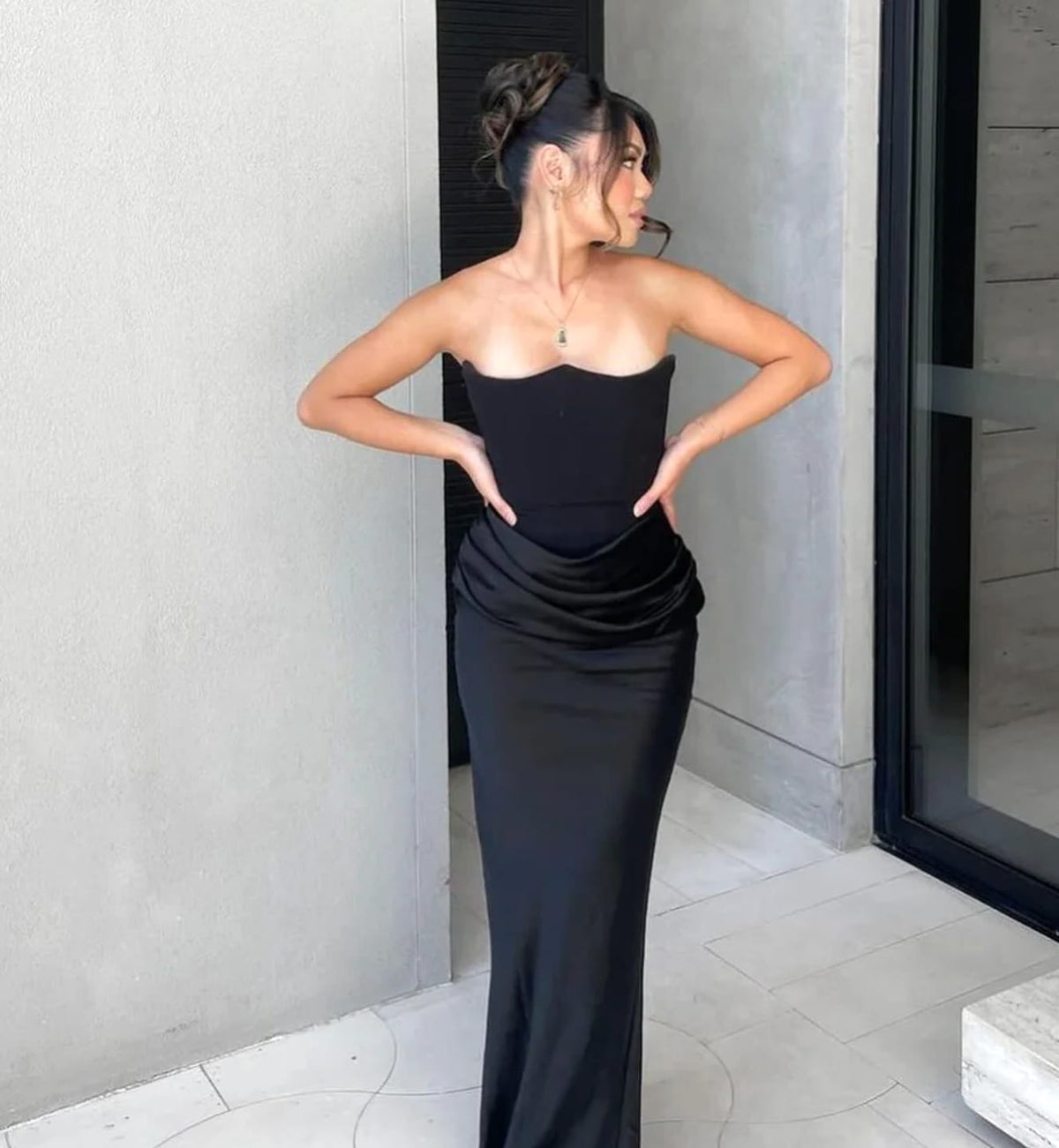 Black corset maxi dress with strapless bodice and front draping