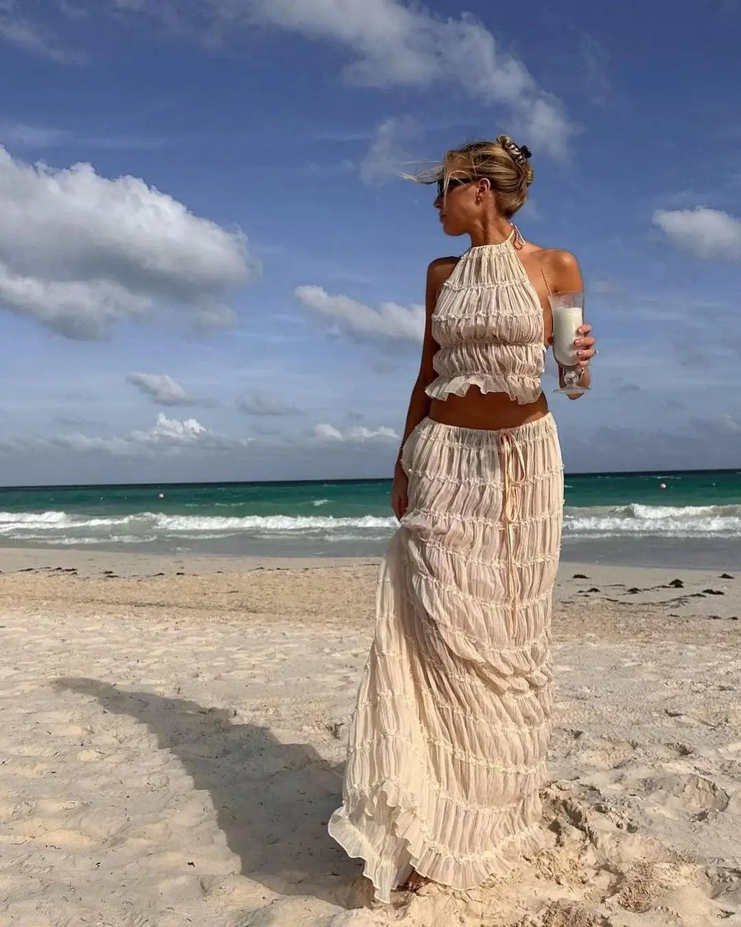 Cream ruffle halter two-piece set worn on a sandy beach