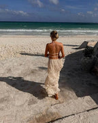 Cream ruffle halter two-piece set walking along the shoreline
