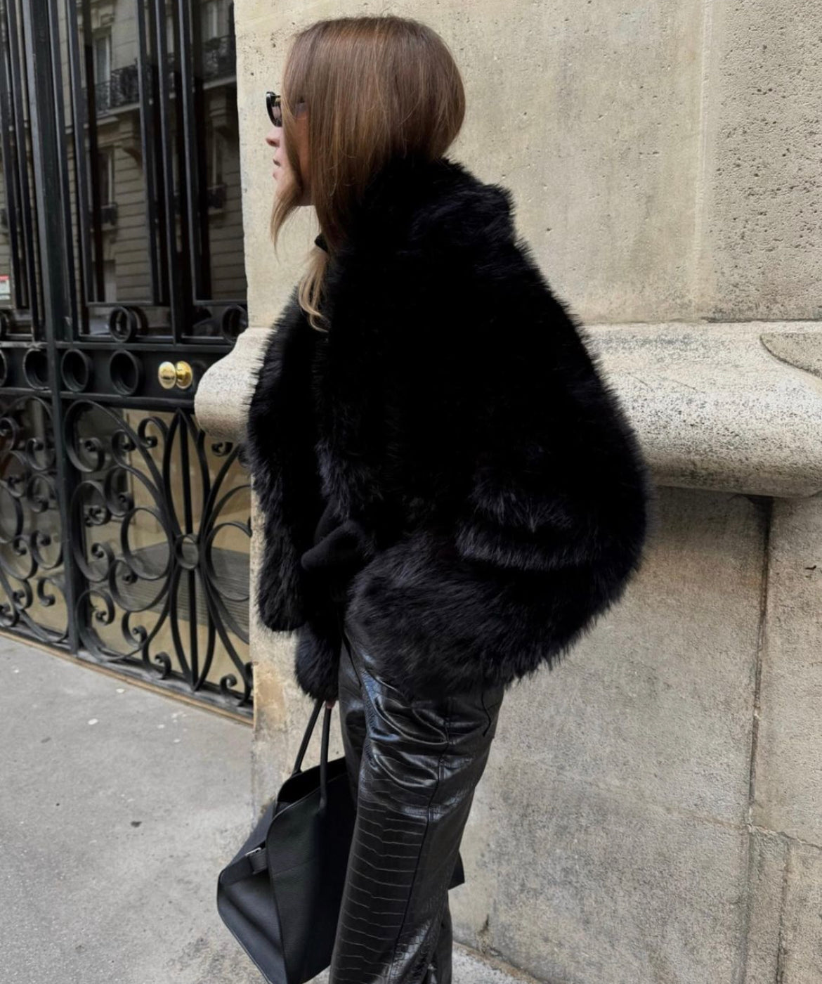 Black faux fur coat styled with a dress, full length view
