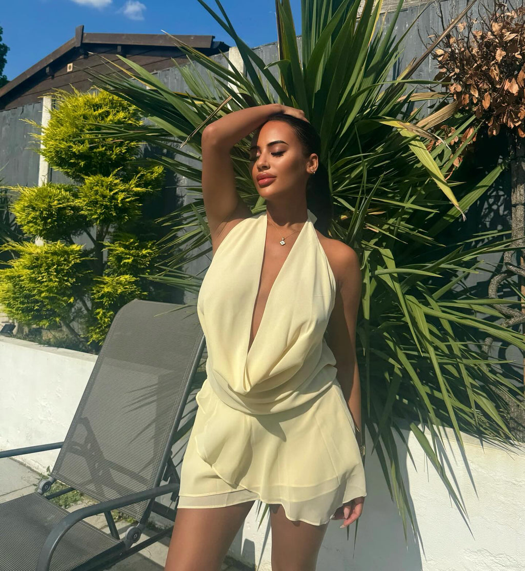 Full-length look at the butter yellow mini dress and its plunging neckline.
