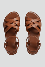 Brown flat sandals with crisscross straps, top-down product shot
