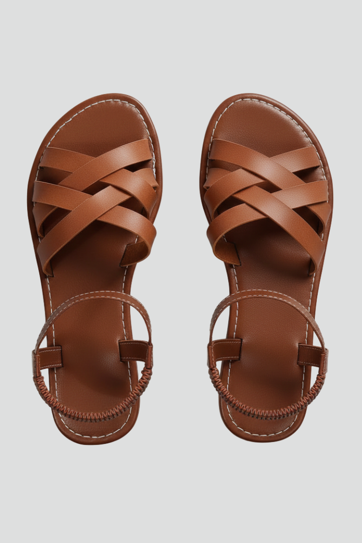 Brown flat sandals with crisscross straps, top-down product shot