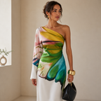 White one-shoulder maxi dress styled with a black shoulder bag