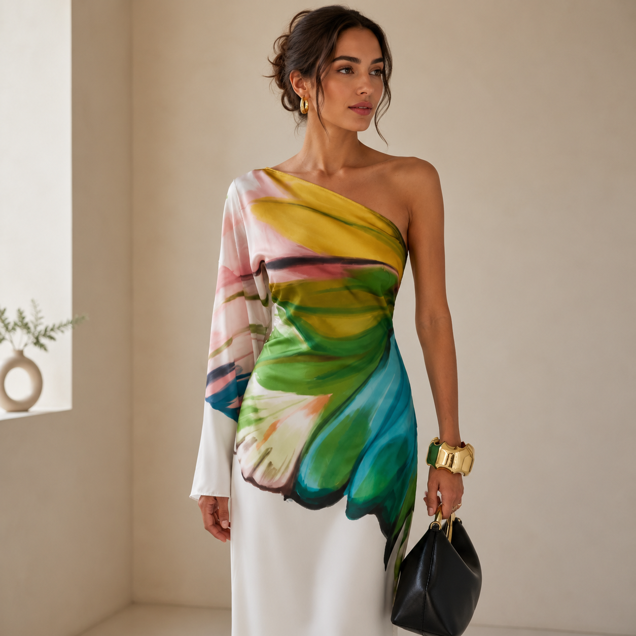 White one-shoulder maxi dress styled with a black shoulder bag