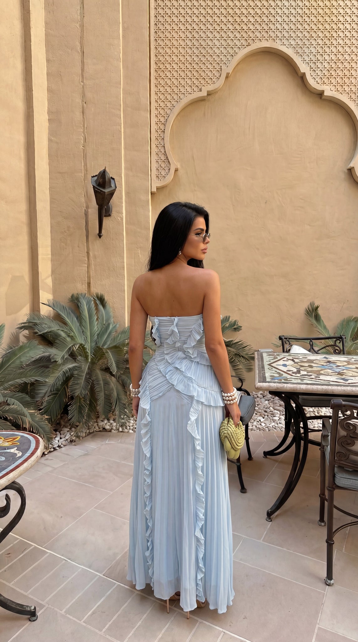 Detail view of the strapless maxi dress's asymmetrical vertical pleating.