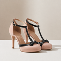 Baby pink T-strap platform heels with black trim, studio shot