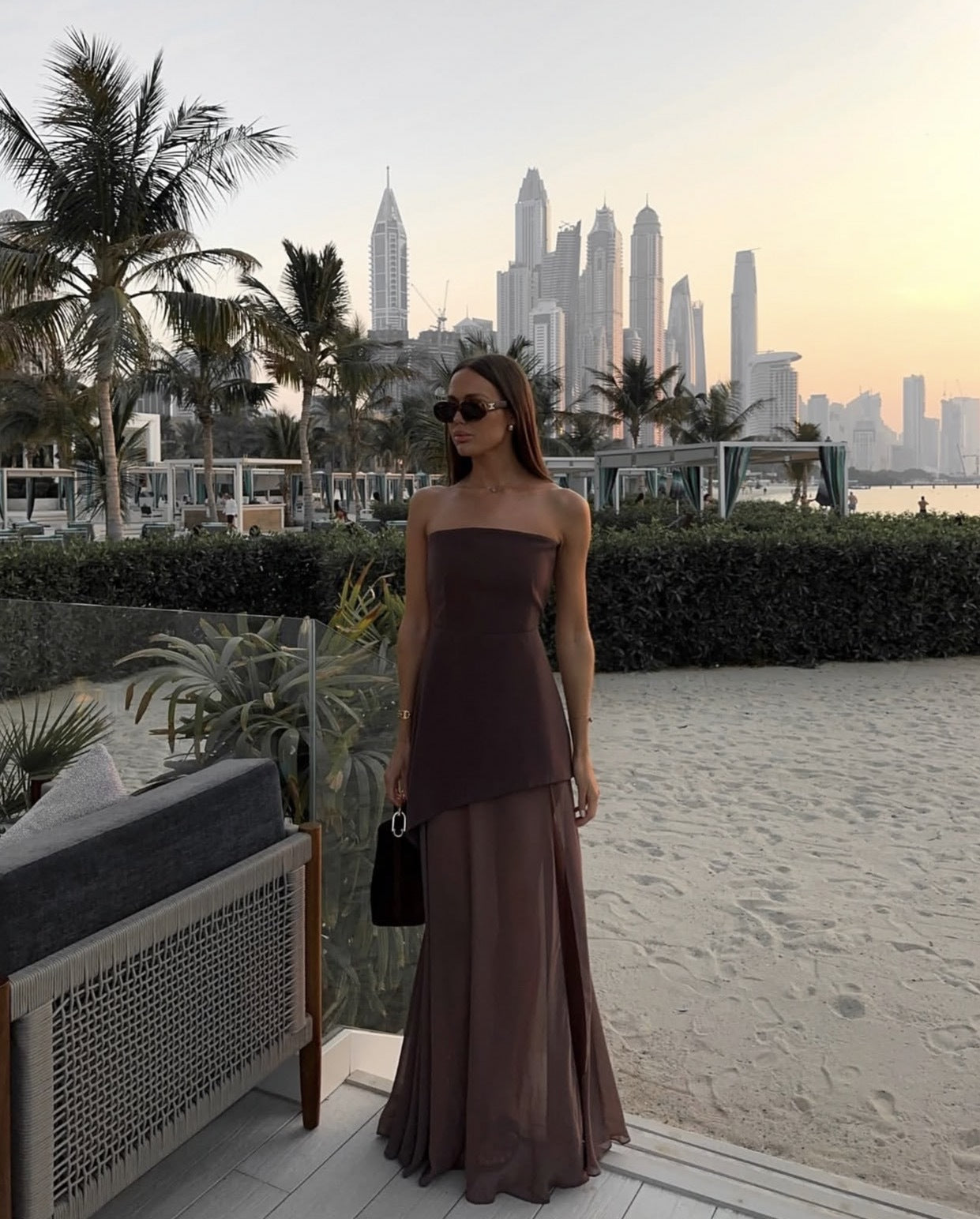 Brown asymmetrical maxi dress with a flowing, uneven hemline