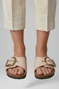 Cream buckle comfort sandals worn with tailored trousers, front view